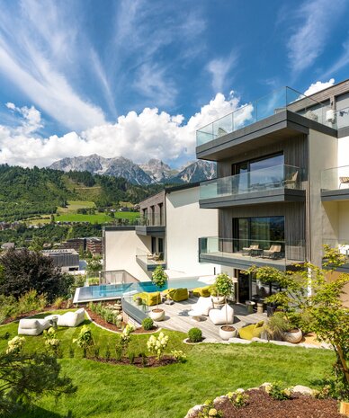 Modernes Mehrfamilienhaus mit Balkonen und gepflegtem Garten.