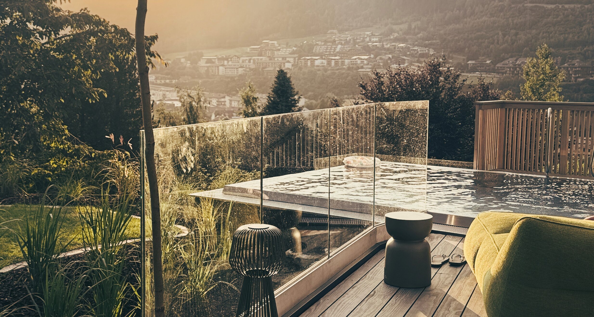 Topfpflanze auf Holzdiele mit Blick ins Tal bei Sonnenuntergang.