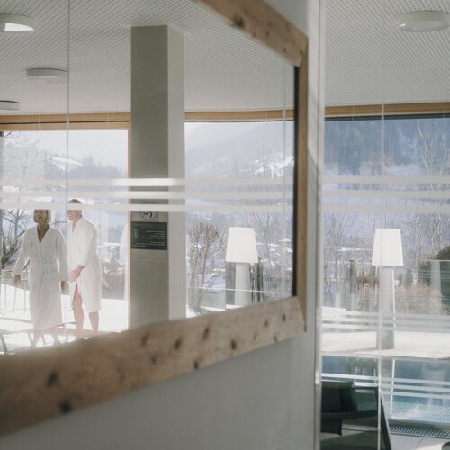 Zwei Gäste im Bademantel vor Glas-Lobby