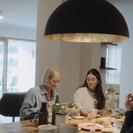 Two women dining at a wooden table with breakfast dishes